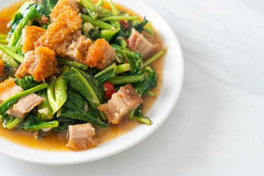 Kızarmış lahana sebzesi ve kıtır domuz eti Asya yemeği.