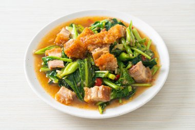 Kızarmış lahana sebzesi ve kıtır domuz eti Asya yemeği.