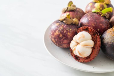 Taze taze mangosteen meyveleri beyaz tabakta
