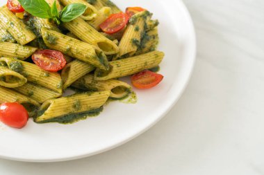 Pesto soslu ve domatesli makarna. Vejetaryen ve vejetaryen yemek tarzı.