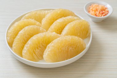 Taze soyulmuş zeytin, greyfurt ya da beyaz tabakta Shaddock.