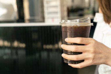 Kapalı el, siyah kahve fincanı tutuyor.