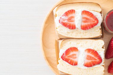 gözlemeli sandviç, çilekli taze krema, ahşap tabakta.