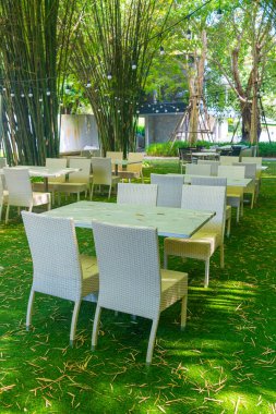 Boş hasır masa ve sandalye bambu bahçesi olan açık hava restoranında.