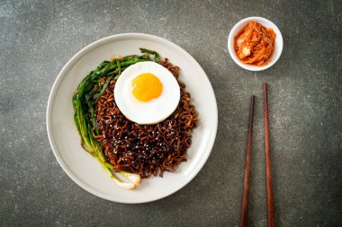 Ev yapımı kurutulmuş Kore baharatlı baharatlı siyah sos kızarmış yumurta ve kimchi ile hazır erişte.