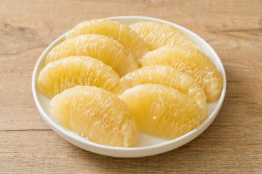 Taze soyulmuş zeytin, greyfurt ya da beyaz tabakta Shaddock.