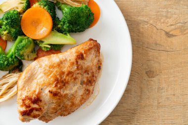 Beyaz tabakta sebzeli ızgara tavuk bifteği