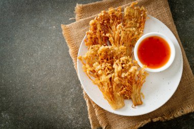 Kızarmış enoki mantarı ya da baharatlı soslu altın iğneli mantar - vejetaryen yemek tarzı.