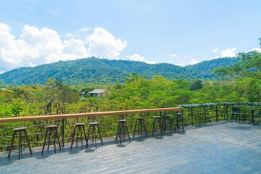 Balkonda boş bir bank ve bar taburesi var.