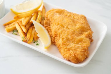 balık ve patates kızartması - kızarmış balık fileto patates cipsi ve limonlu beyaz tabak