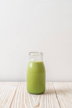 Ahşap arka planda süt şişeli kibrit yeşil çay