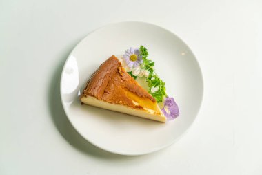 Bask Yanmış Cheesecake süslemesi. Beyaz tabakta çiçekler.