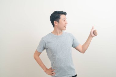 Beyaz arka planda eli işaret eden ya da sunan genç Asyalı adam portresi