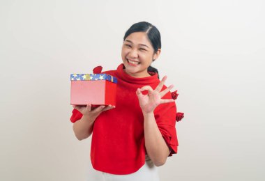 Noel festivali için kırmızı tişörtlü mutlu Asyalı kadın portresi.