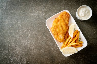 balık ve patates kızartması - kızarmış balık fileto patates cipsi ve limonlu beyaz tabak