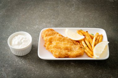 balık ve patates kızartması - kızarmış balık fileto patates cipsi ve limonlu beyaz tabak