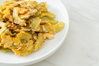 Kızarmış acı kabağı tabakta yumurta ile karıştır