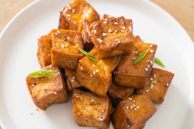 Beyaz susamlı kızarmış tofu ve teriyaki sosu. Vejetaryen ve vejetaryen yemek tarzı.