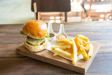 Tahta tepside peynirli biftek ve patates cipsi.