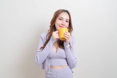 Beyaz arka planda kahve fincanı ya da kupa tutan güzel Asyalı kadın portresi