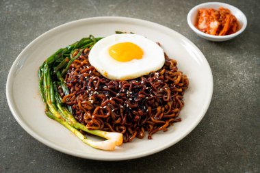 Ev yapımı kurutulmuş Kore baharatlı baharatlı siyah sos kızarmış yumurta ve kimchi ile hazır erişte.