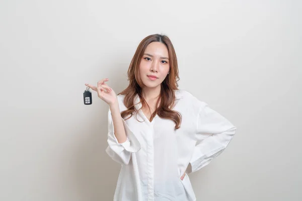 漂亮的亚洲女人拿着白色背景的车钥匙 — 图库照片