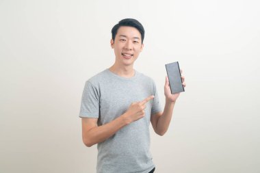 Beyaz arka planda akıllı telefon ve cep telefonu kullanan ya da konuşan genç Asyalı adam