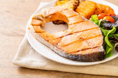 Kızarmış somon bifteği fileto, sebze ve patates kızartması.