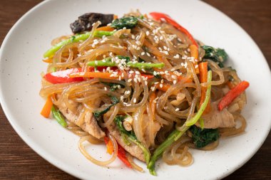 Japchae ya da karışık Kore vermicelli erişte sebzeli ve üzerine beyaz susamlı domuz eti - Kore geleneksel yemek tarzı