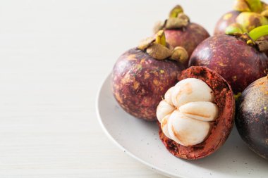 Taze taze mangosteen meyveleri beyaz tabakta
