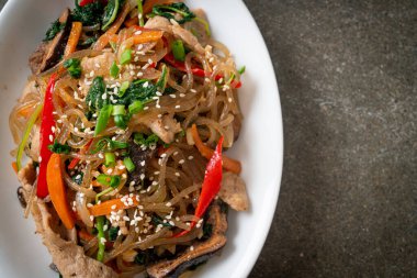 Japchae ya da karışık Kore vermicelli erişte sebzeli ve üzerine beyaz susamlı domuz eti - Kore geleneksel yemek tarzı