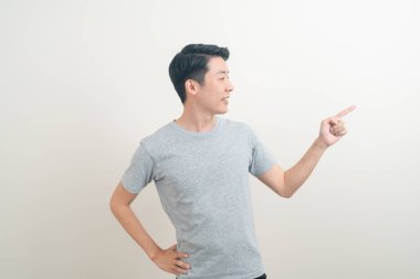 Beyaz arka planda eli işaret eden ya da sunan genç Asyalı adam portresi