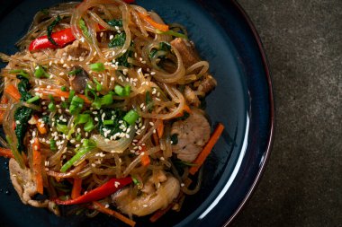 Japchae ya da karışık Kore vermicelli erişte sebzeli ve üzerine beyaz susamlı domuz eti - Kore geleneksel yemek tarzı