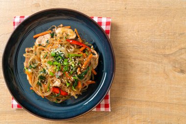Japchae ya da karışık Kore vermicelli erişte sebzeli ve üzerine beyaz susamlı domuz eti - Kore geleneksel yemek tarzı