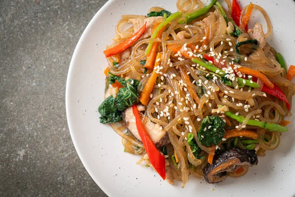Japchae ya da karışık Kore vermicelli erişte sebzeli ve üzerine beyaz susamlı domuz eti - Kore geleneksel yemek tarzı