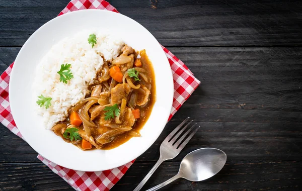 Dilimlenmiş domuz eti, havuç ve soğanlı Japon körili pilavı. Asya usulü.