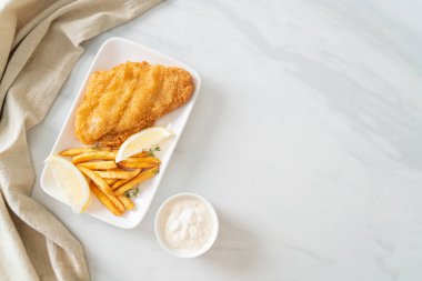 balık ve patates kızartması - kızarmış balık fileto patates cipsi ve limonlu beyaz tabak