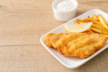 balık ve patates kızartması - kızarmış balık fileto patates cipsi ve limonlu beyaz tabak