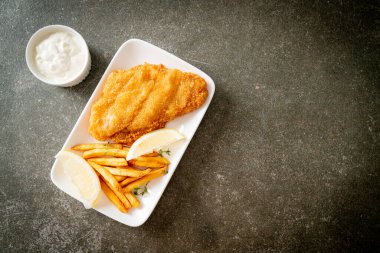 balık ve patates kızartması - kızarmış balık fileto patates cipsi ve limonlu beyaz tabak