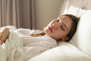Beyaz yastıkla uyuyan güzel Asyalı kadın portresi.