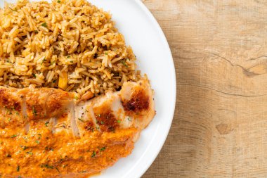 Kırmızı köri soslu ızgara tavuk bifteği ve pilav. Müslüman usulü.