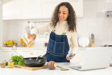 Latin kadın blogda paylaşmak için mutfakta video ve yemek çekiyor.
