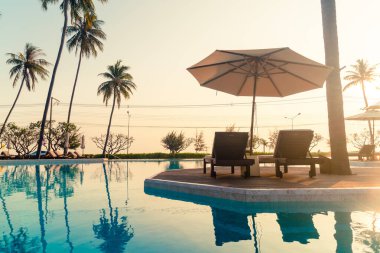 Okyanus geçmişi olan yüzme havuzunun etrafında havuzu olan şemsiyeler - tatil ve tatil kavramı