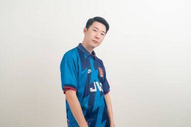 Bangkok, THAILAND - 27 Kasım 2021: beyaz arka planda Arsenal tişörtü giyen genç Asyalı. Arsenal, Londra 'nın en ünlü futbol kulübüdür..