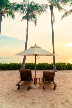 Plaj sandalyesi ve okyanus geçmişi olan şemsiye - tatil ve tatil kavramı