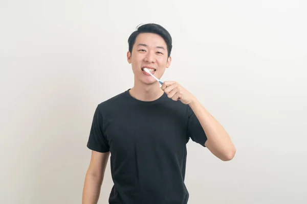Genç Asyalı Adam Beyaz Arka Planda Dişlerini Fırçaladı — Stok fotoğraf