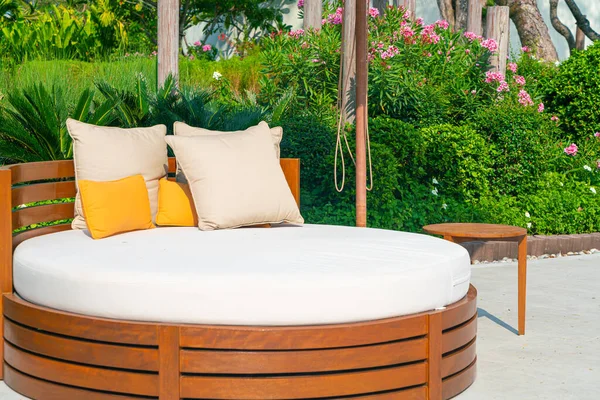 Bahçedeki şemsiyeli teras sandalyesinde yastıklar.