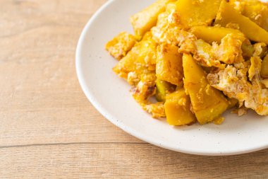 Beyaz tabakta yumurtalı kızarmış balkabağı.