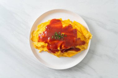 Omlet ambalajlı kızarmış pirinç ya da Japon usulü Omurice. Asya usulü.