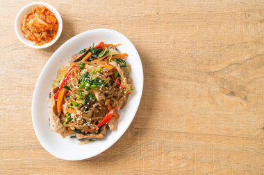 Japchae ya da karışık Kore vermicelli erişte sebzeli ve üzerine beyaz susamlı domuz eti - Kore geleneksel yemek tarzı